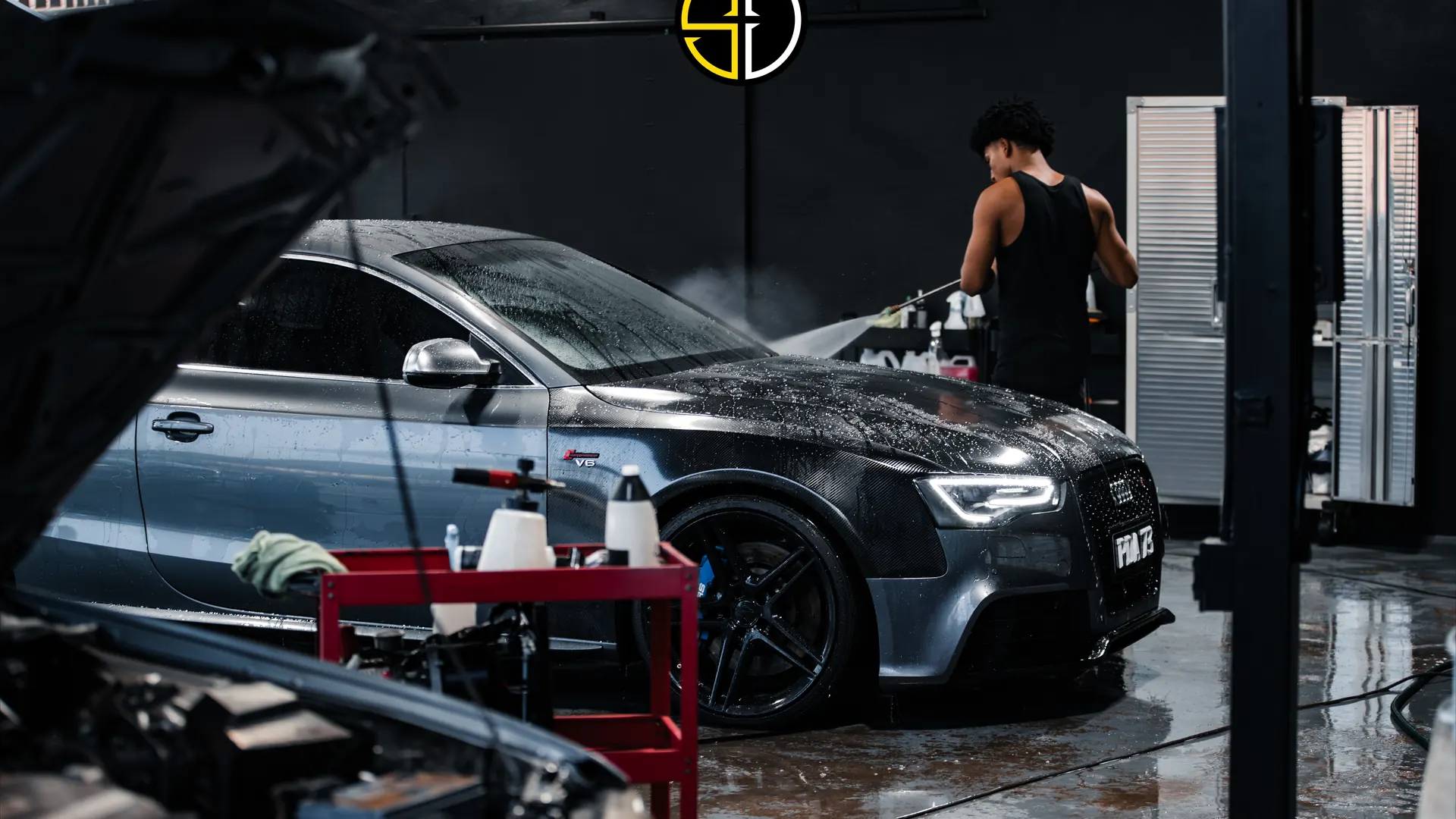 Detailer washing a grey Audi inside the Supreme Details studio in San Juan