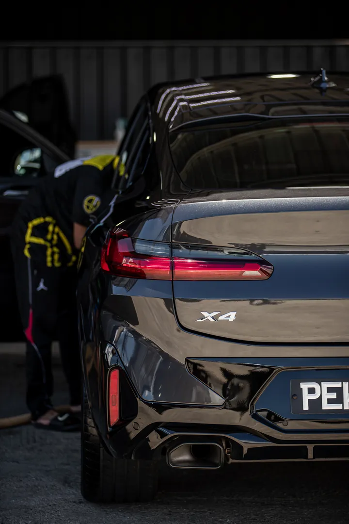 Glossy black BMW X4 being detailed in the Supreme Details studio