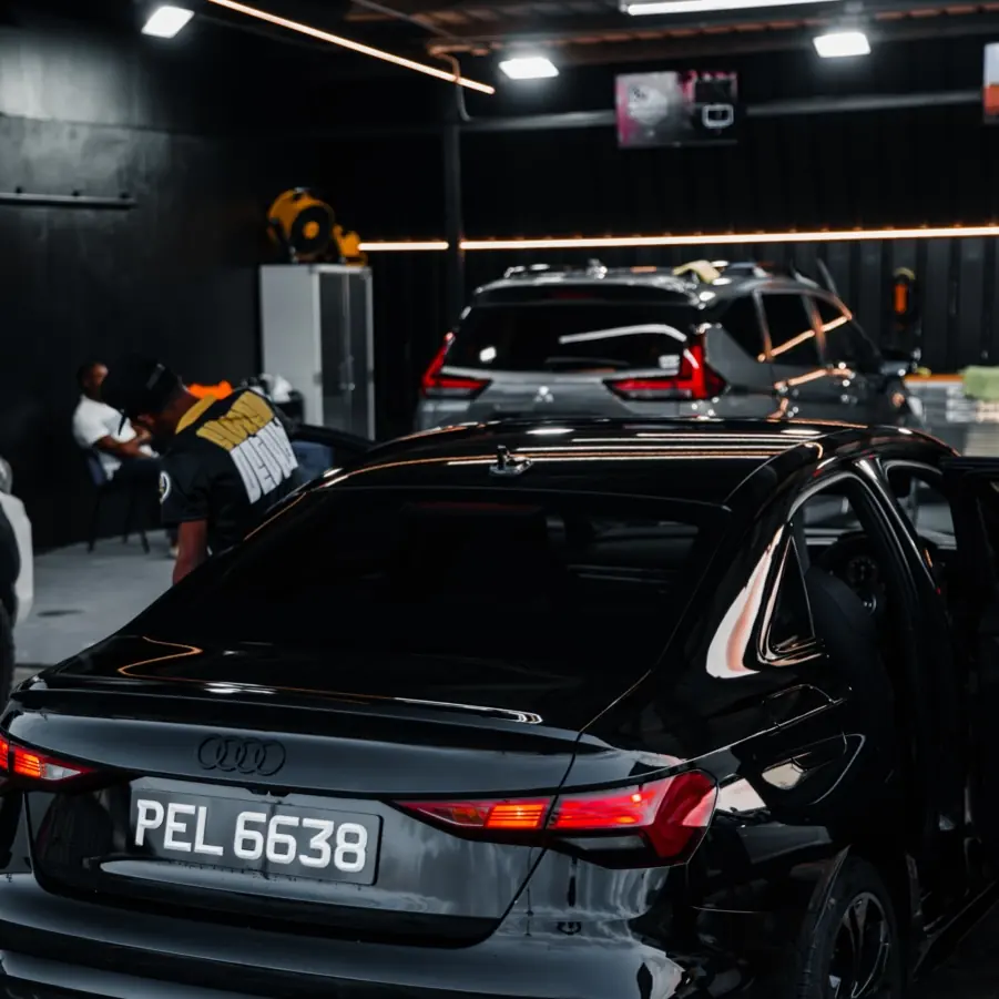 Black Audi sedan with tinted rear windows inside the Supreme Details studio